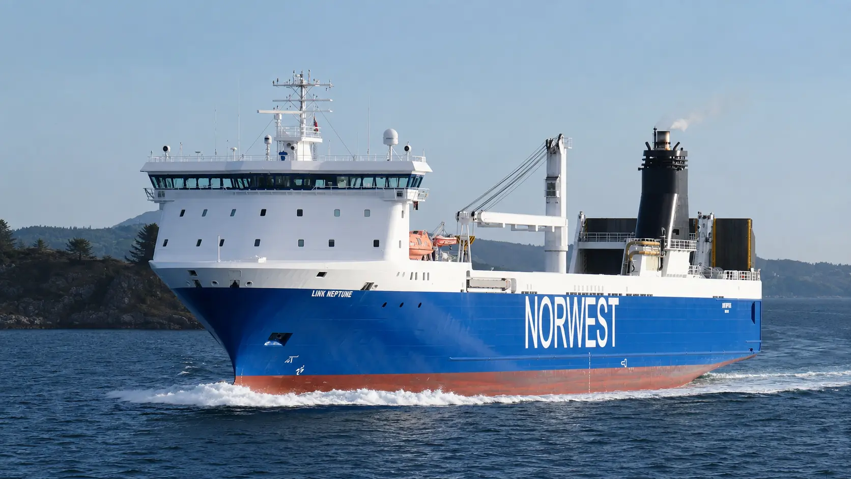 RoRo cargo vessel under way in coastal waters, stern ramp raised and deck crane stowed.
